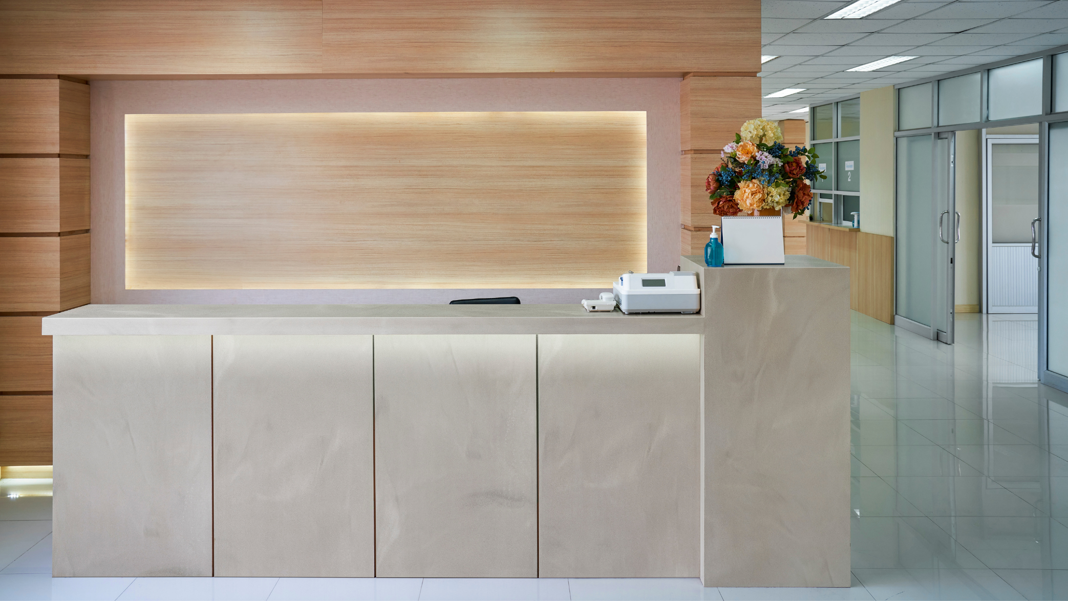 Aplikkacja materiału Corian Solid Surface w przestrzeni wejściowej na ladzie recepcyjnej